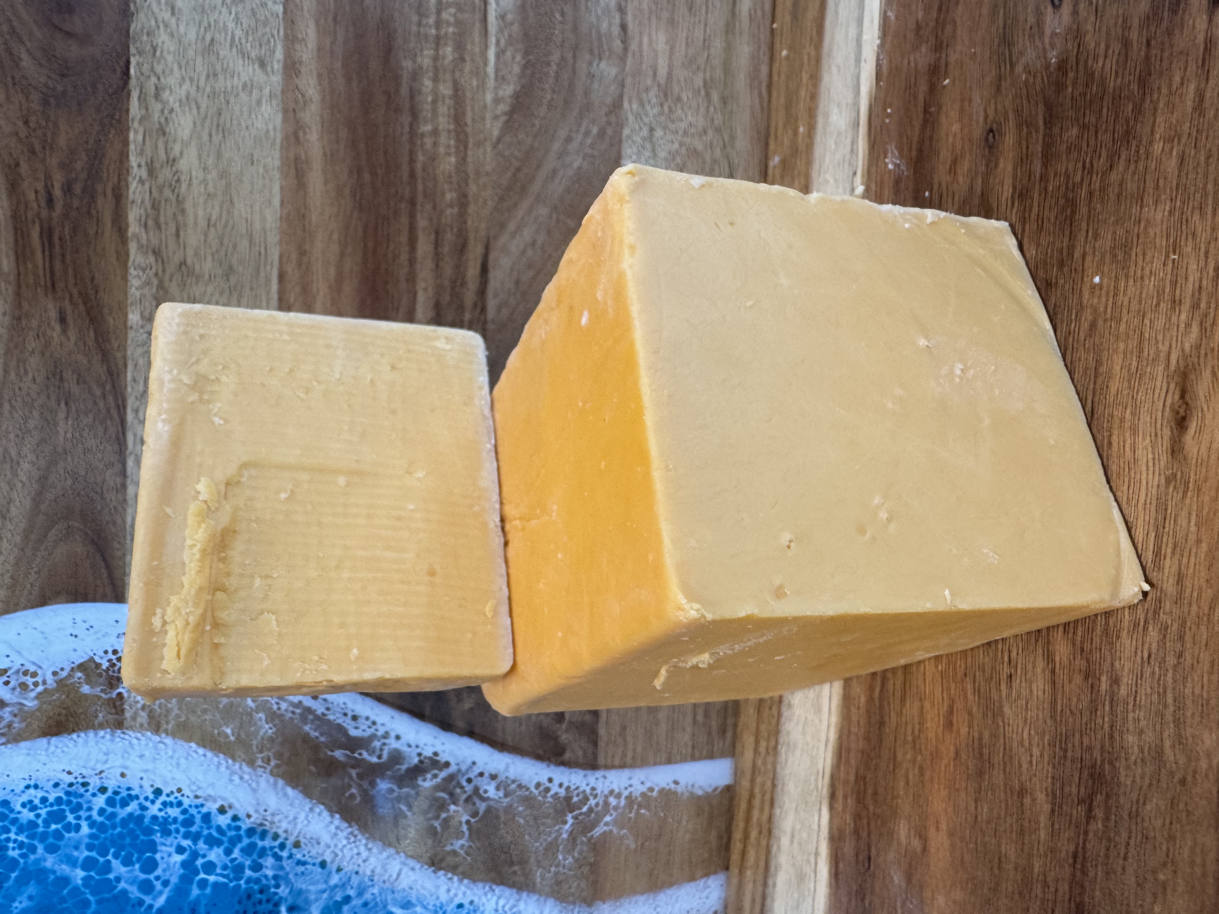 Cut cheese blocks on a wooden board.